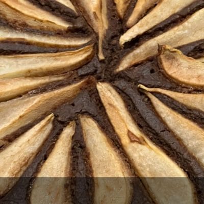 Una torta golosa con ceci, cioccolato, e pere su un piatto elegante.